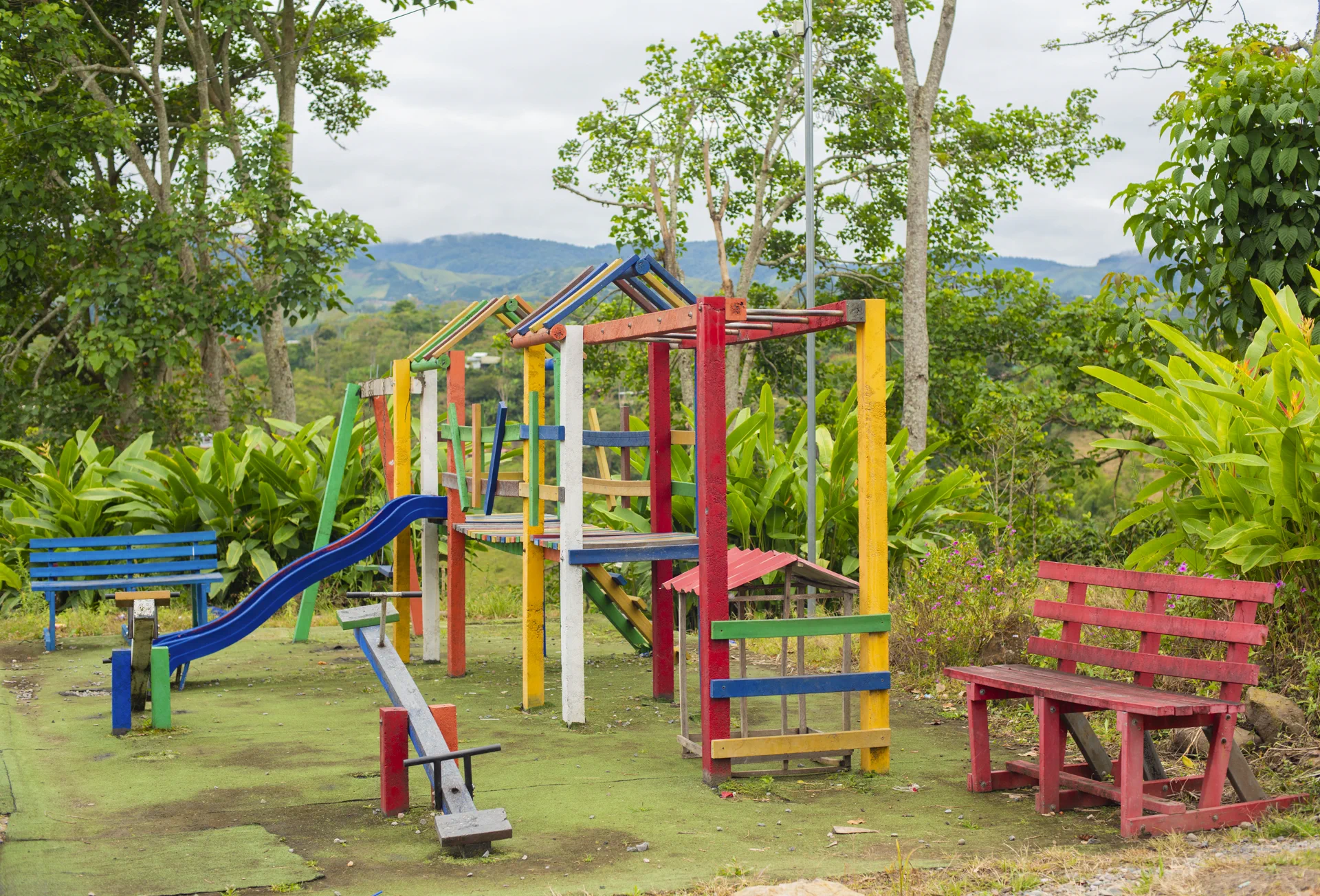 Zona de juegos infantil rodeada de vegetación en la finca