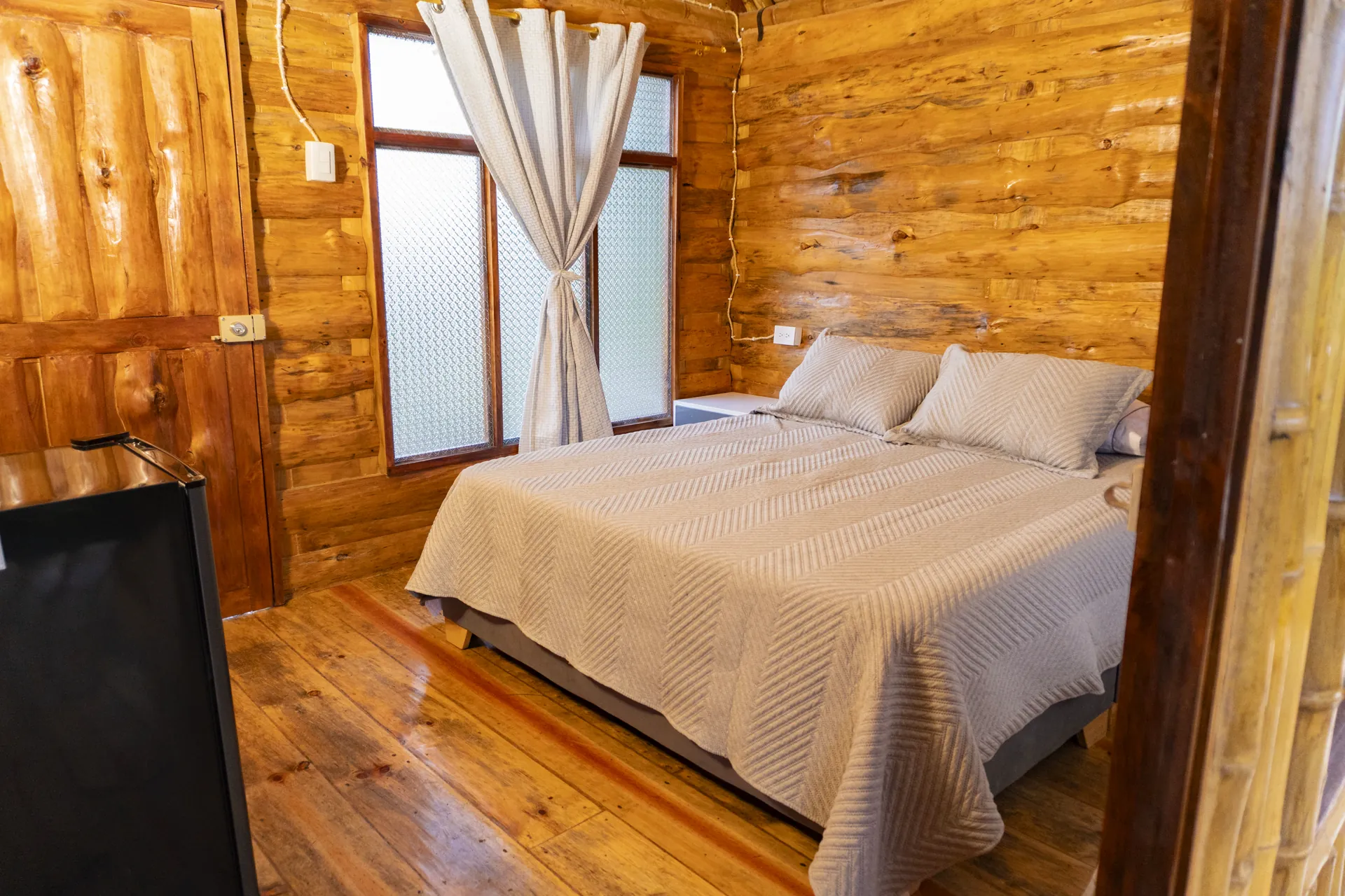 Habitación de cabaña de madera con cama doble y acabados de madera