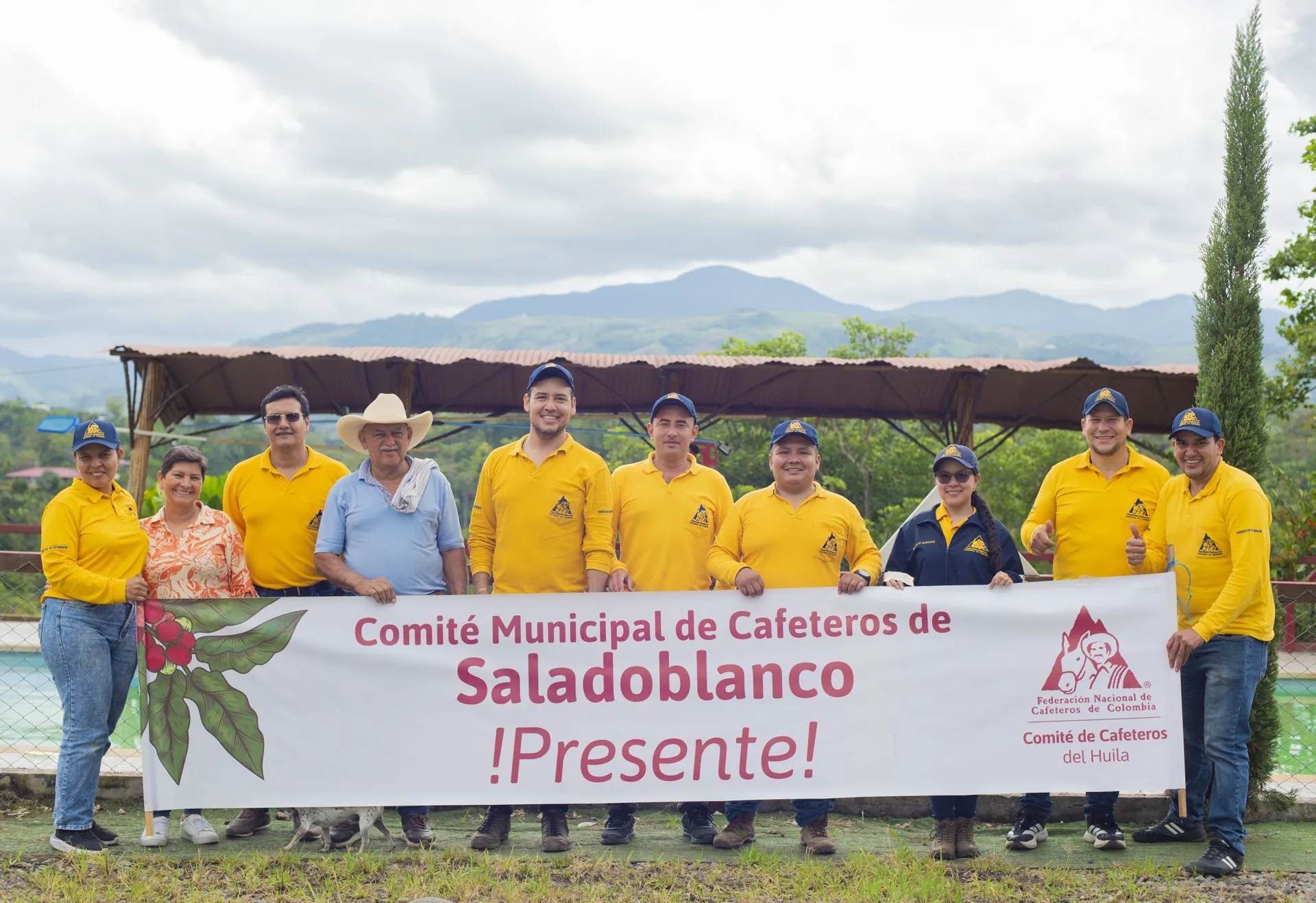 Grupo de personas reunido frente a un aviso en el entorno de la finca